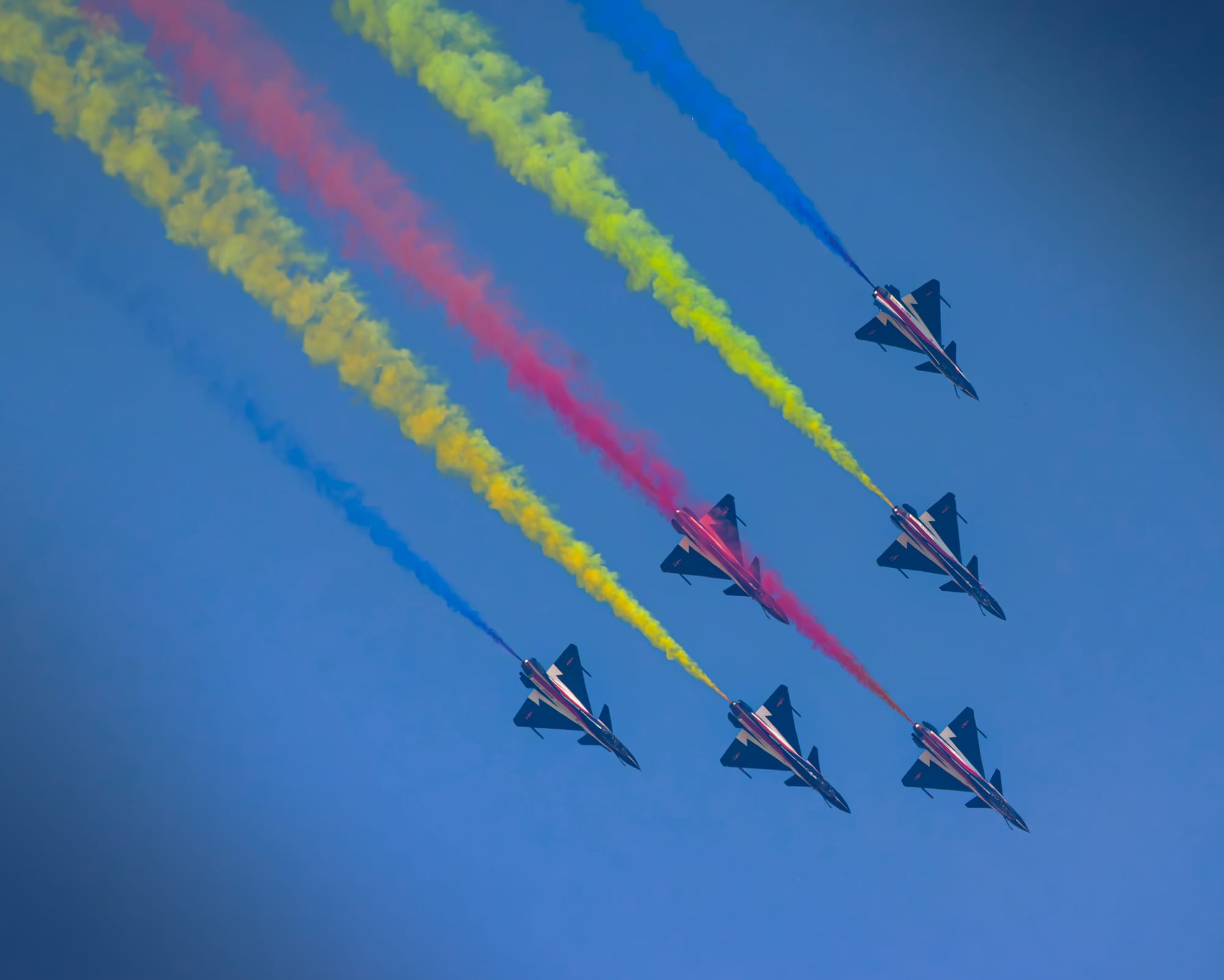 Aerobatic jets trailing colour across the sky