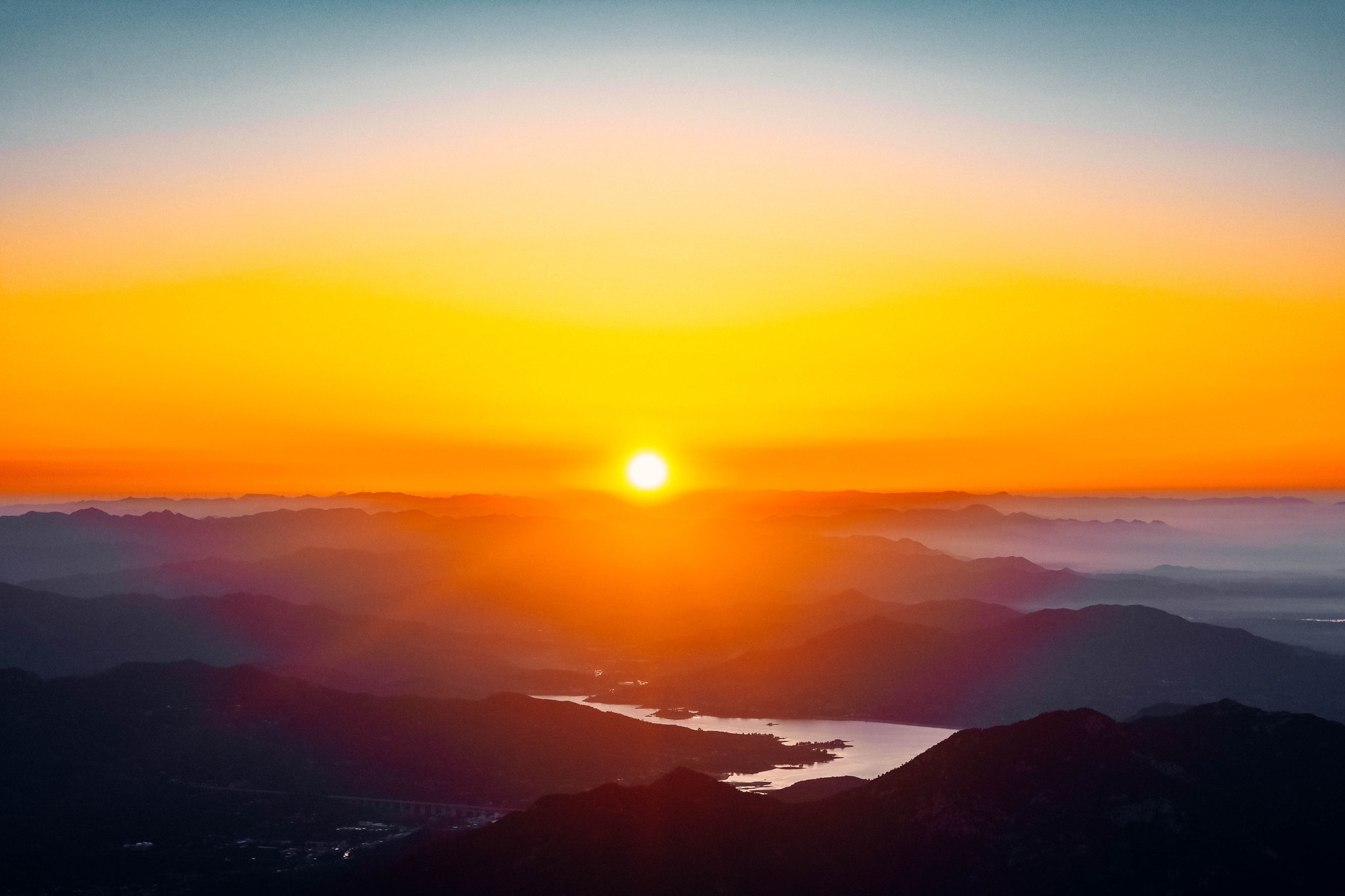 Sunrise over layered mountain ridges