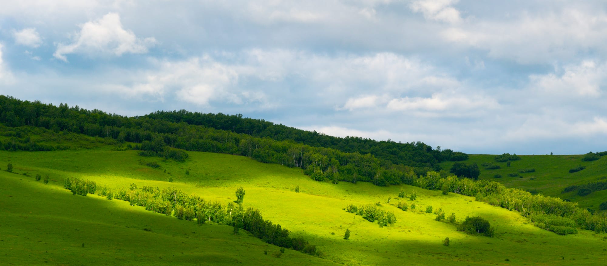 Green hills in bands of light