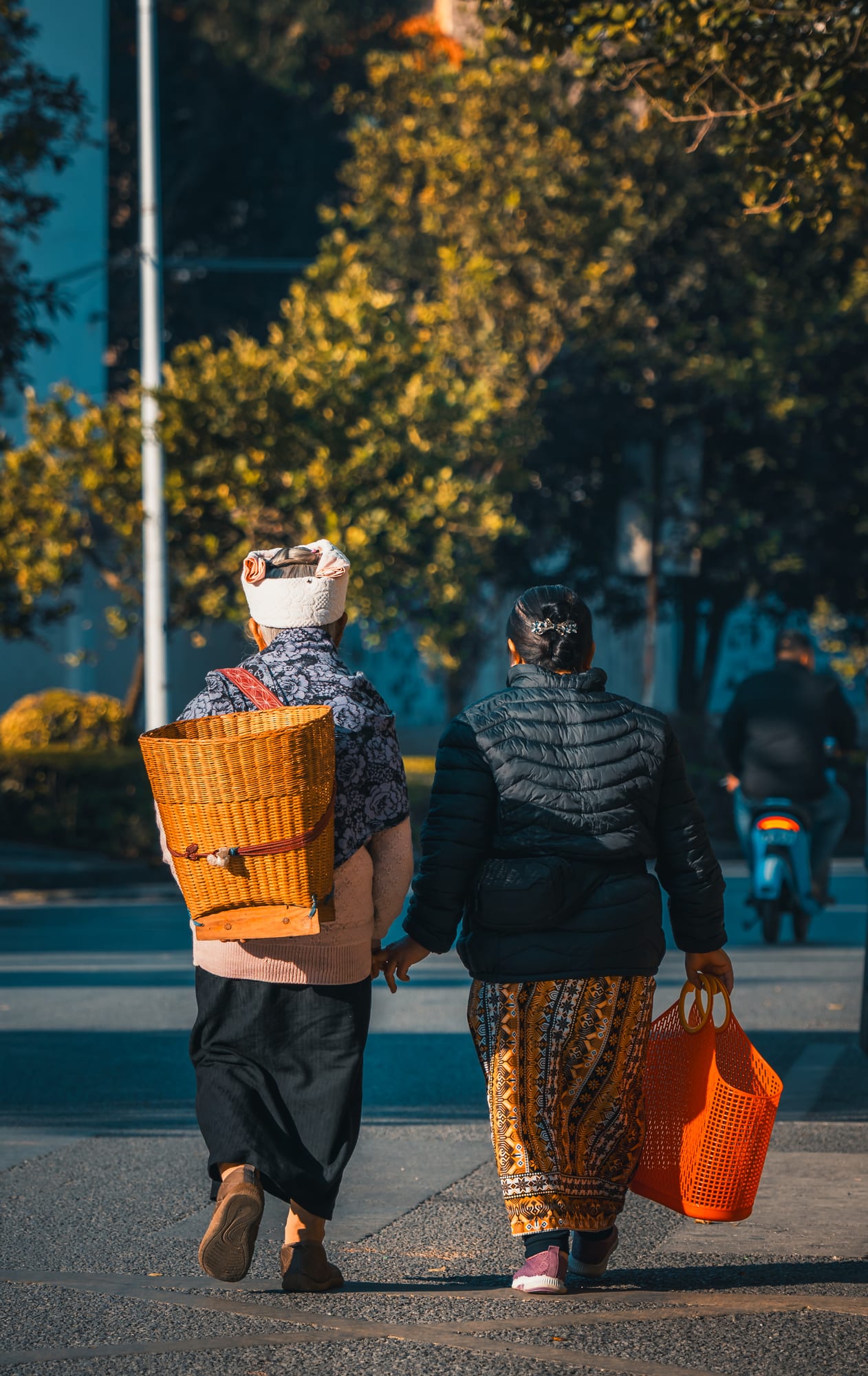 Two people walking down a road in autumn