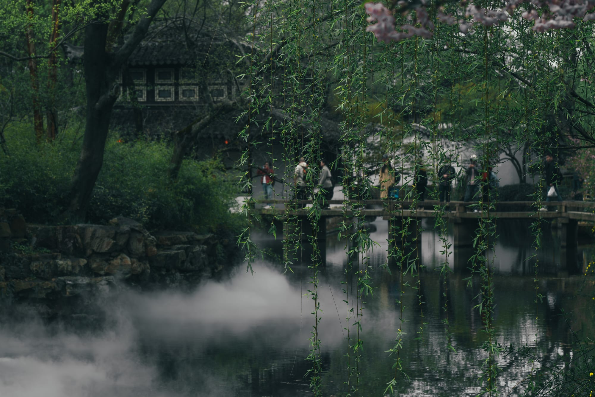 A pavilion over a misty garden pond