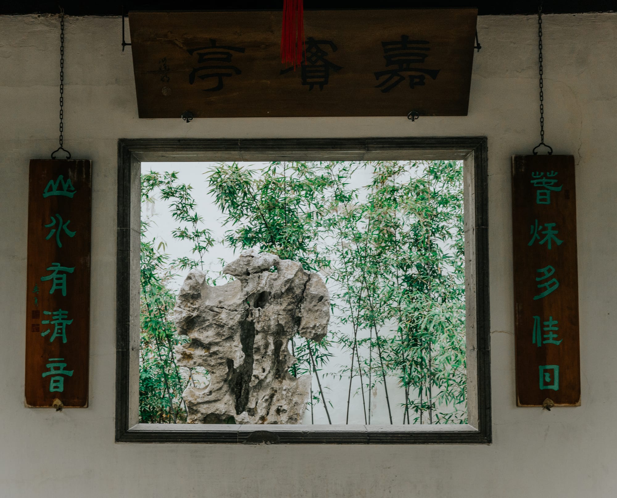 A framed view of bamboo and rockery in a garden