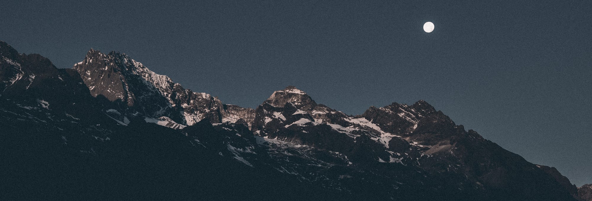 Snow mountains under a moonlit night sky